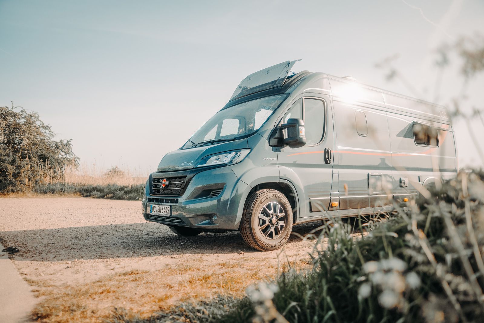 Wohnwagen geparkt auf sandiger Nebenstraße